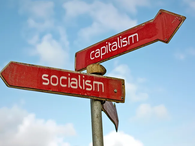 crossroad with socialism and capitalism road signs